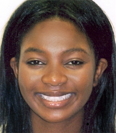 Smiling woman with long dark hair in professional headshot portrait for orthodontics practice