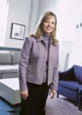 Smiling orthodontist in purple scrubs standing in modern dental office treatment room