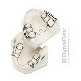 Orthodontic brackets and wires displayed on dental model showing treatment components for teeth alignment.