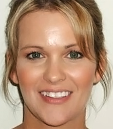 Woman smiling at camera showcasing healthy teeth and orthodontic results in professional portrait setting.