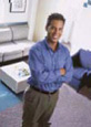 Male orthodontist in blue shirt gesturing in modern dental office treatment room.