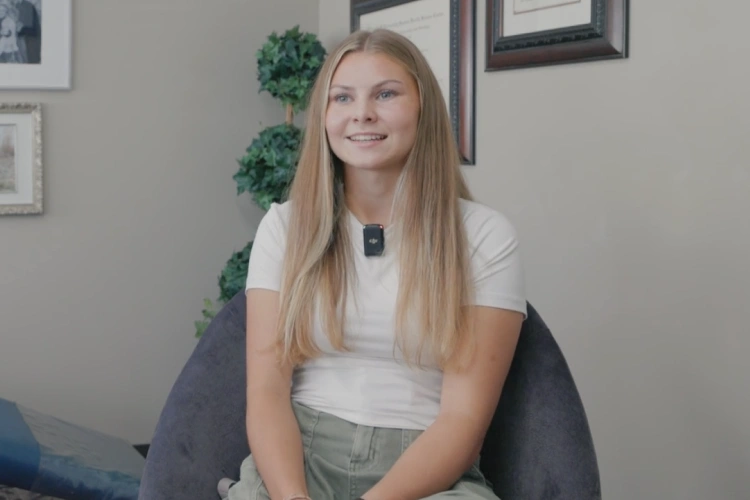 Woman with blonde hair smiling in professional office setting at Tingey Orthodontics.