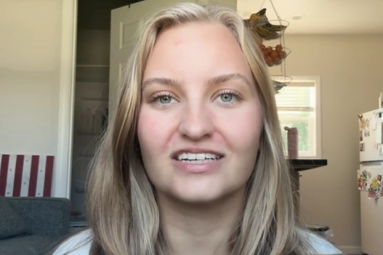 Smiling woman with long blonde hair in a home interior setting for orthodontics practice.